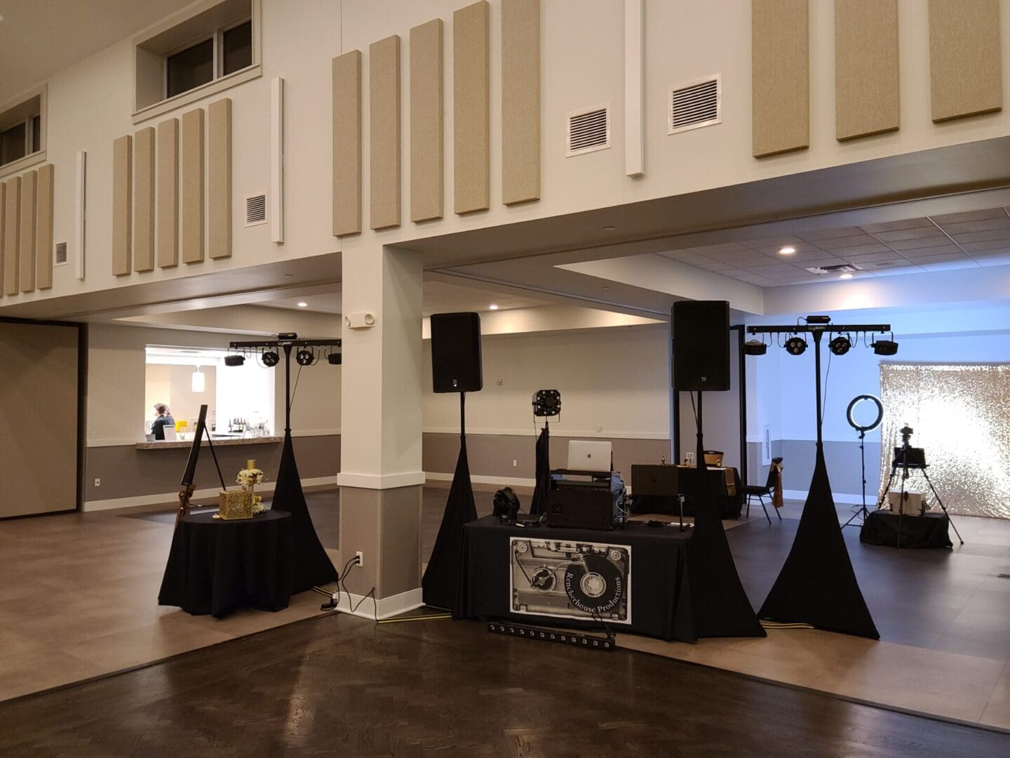 A room with black and white walls, a dj booth and speakers.