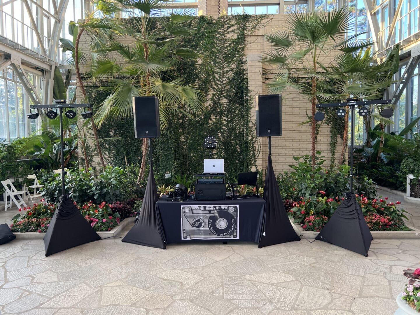 A dj booth with speakers and stands in front of some trees